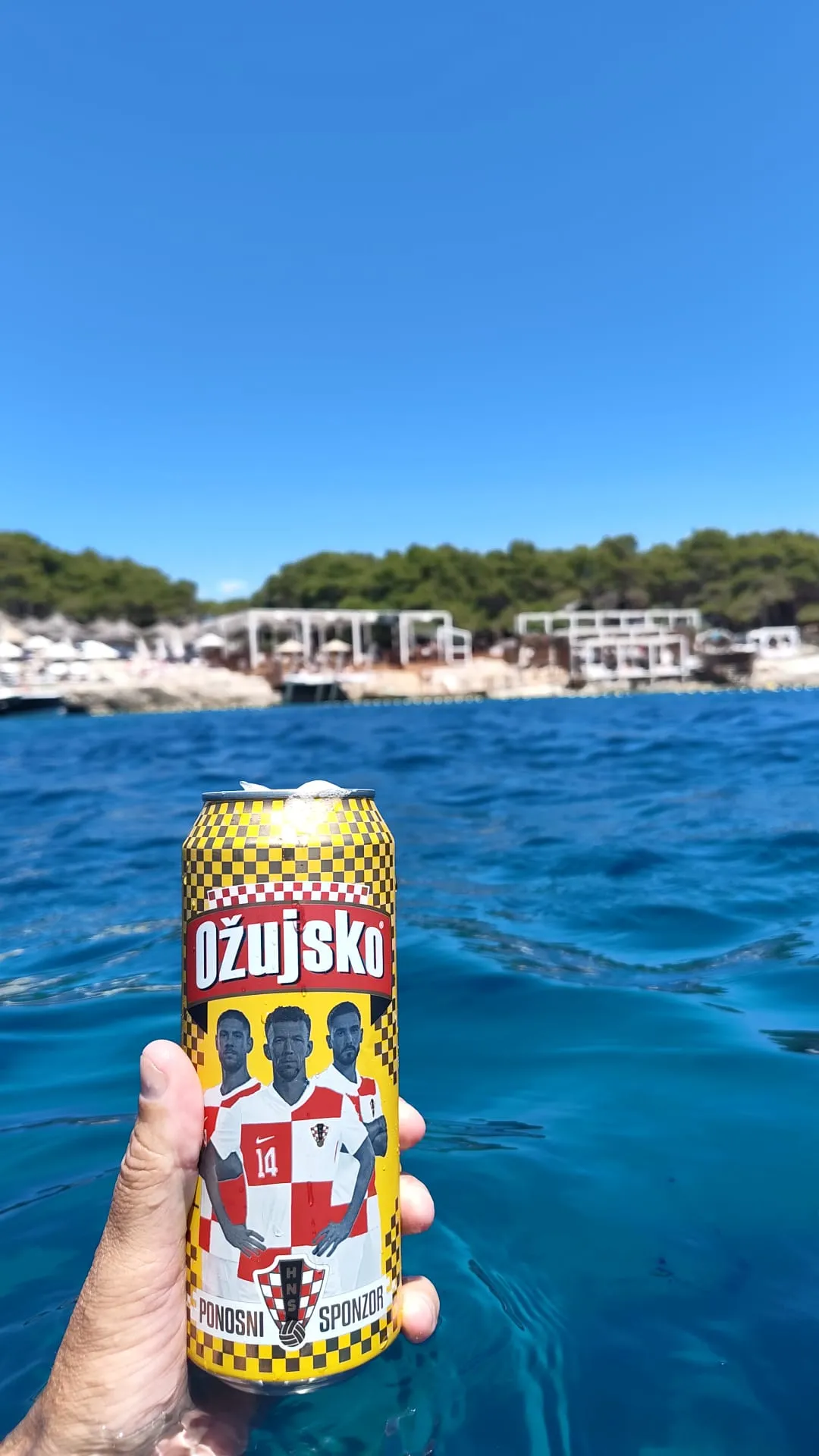 Stu holding a beer in the water